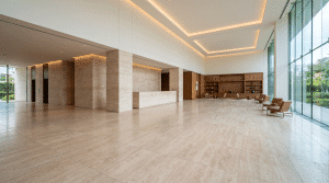 Upscale hotel lobby floored wall to wall in large-format honed ivory travertine with a matching stone reception desk and column surrounds